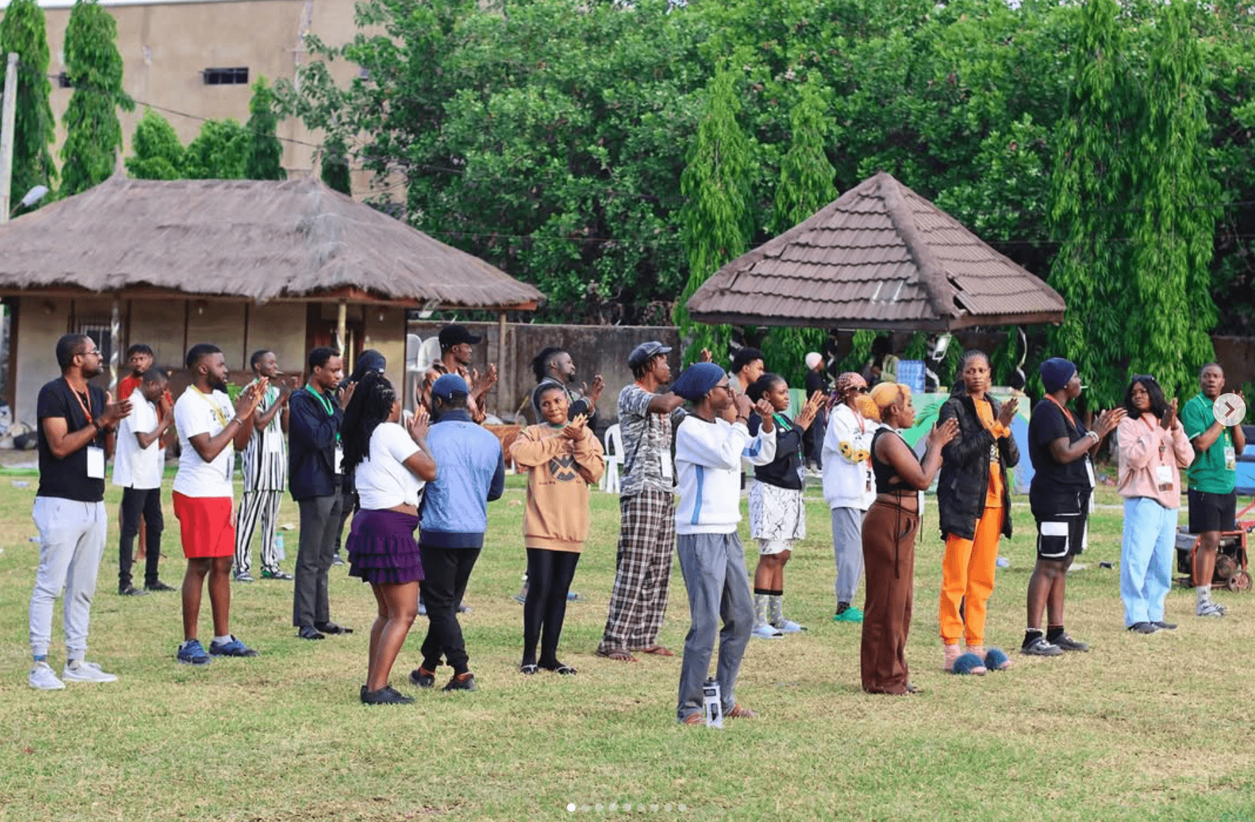 A large group gathered in a circle during an outdoor activity