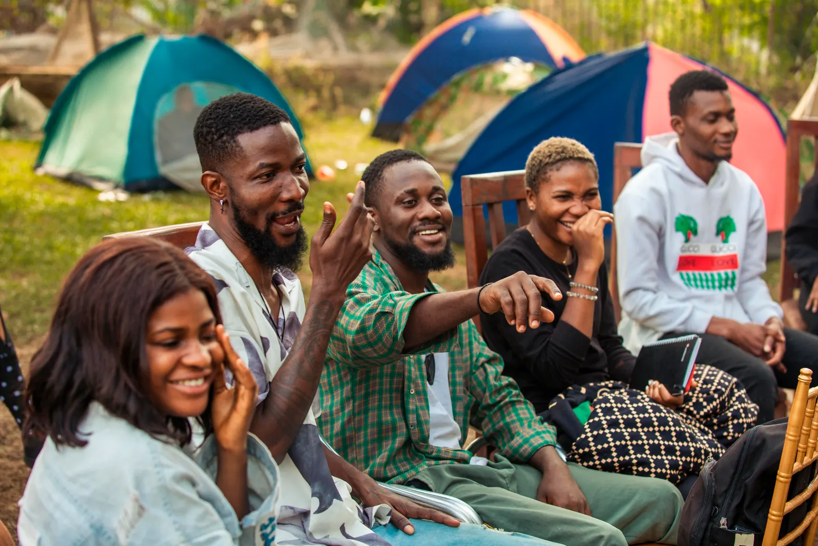 Three friends laughing and pointing during a group session outdoors