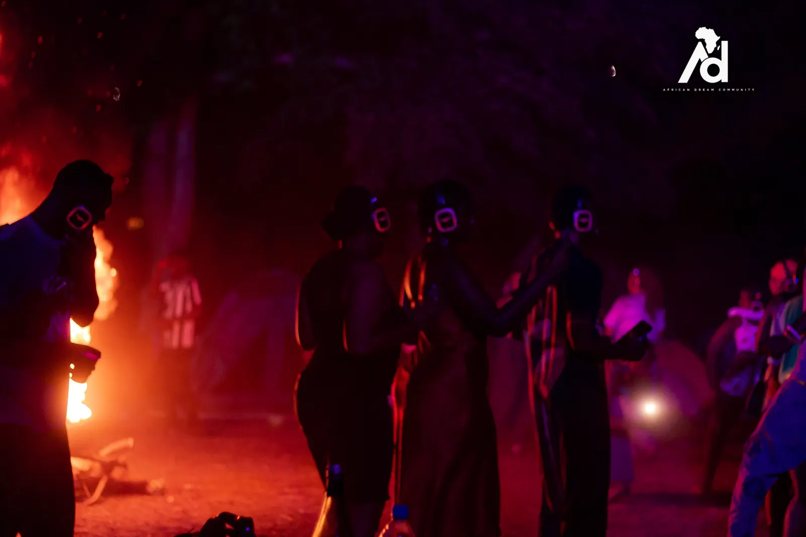 A silent disco at night, dancers in glowing headphones lit red