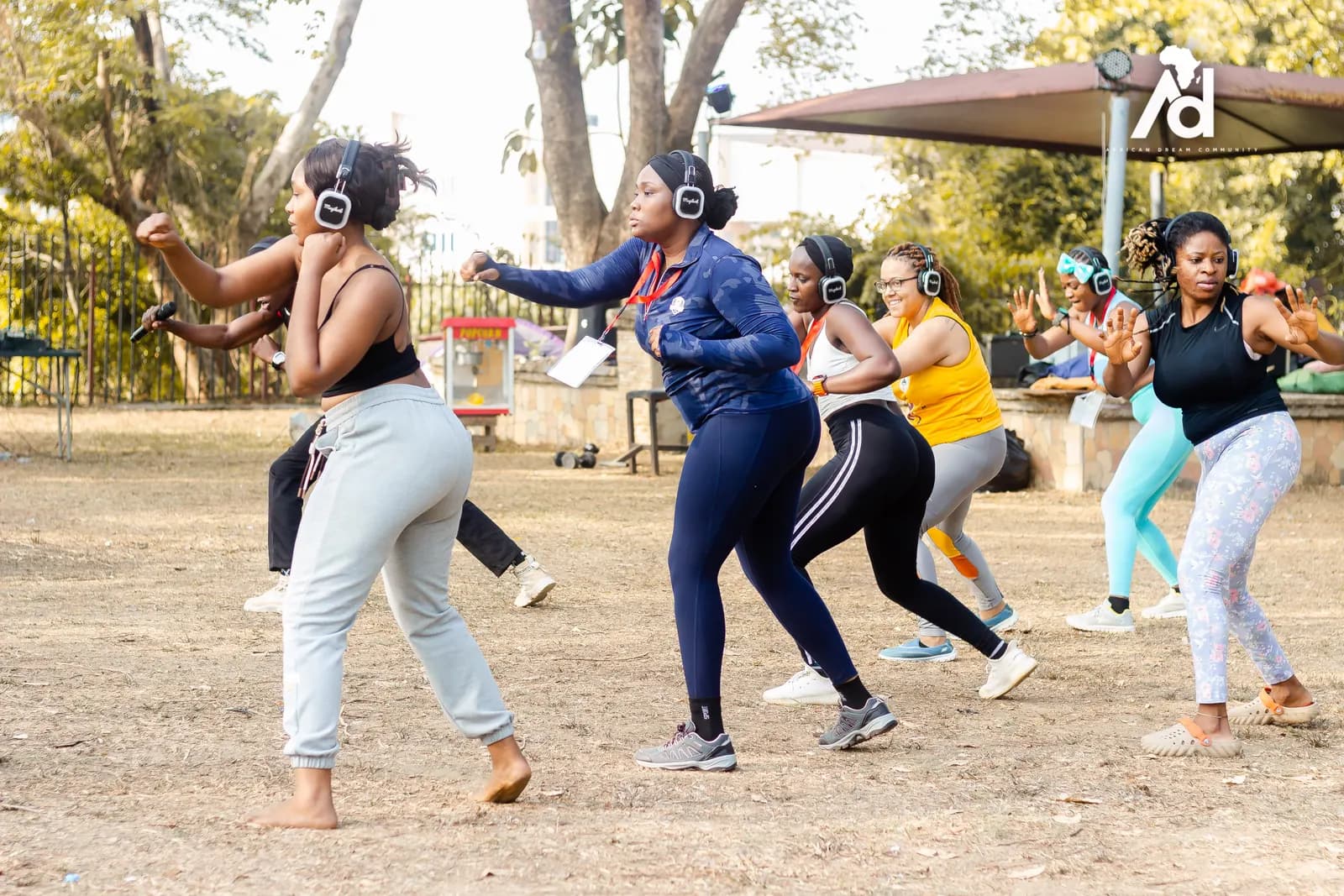Members dancing in a group workout wearing wireless headphones